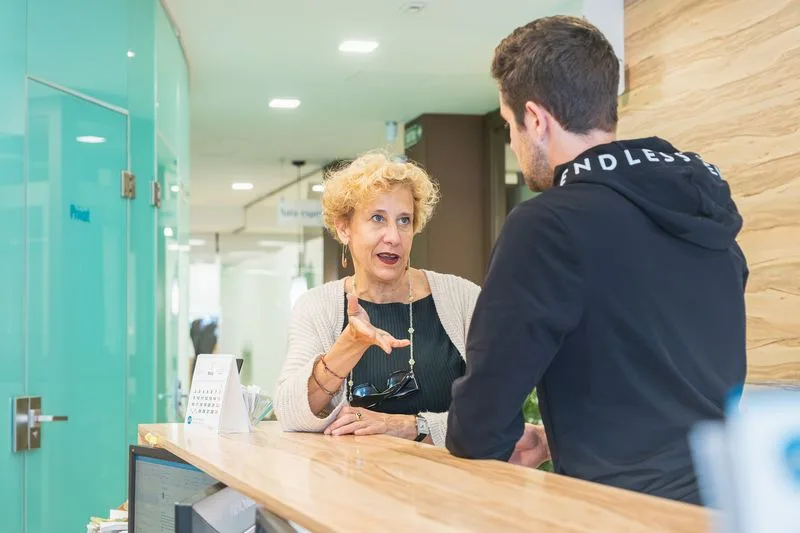 Silvia Rueda atendiendo a un paciente en la recepción del centro